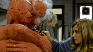 foto dell'artista che ritocca la scultura in cera