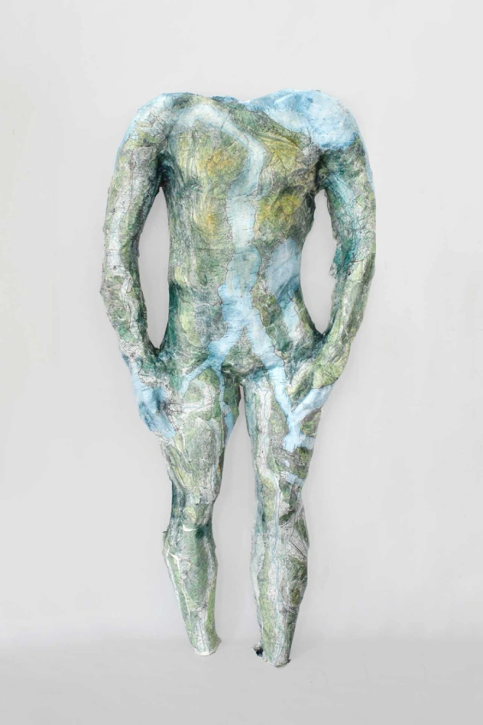 Scultura con benda ingessata e carte geografiche