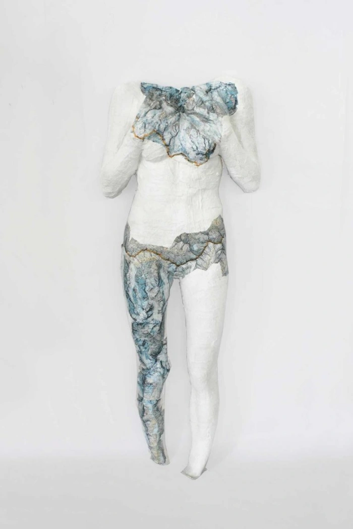 Scultura con benda ingessata e carte geografiche