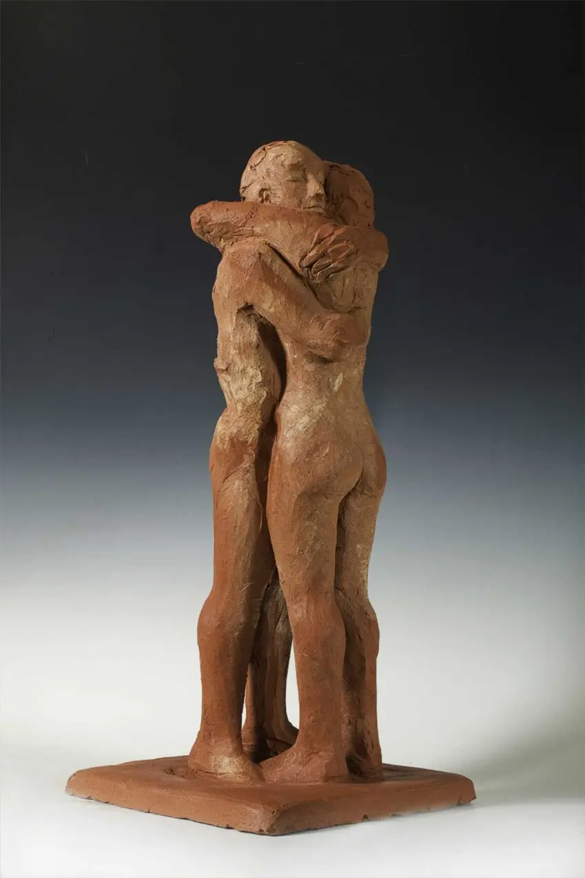 Scultura in terracotta: un uomo e una donna si abbracciano.